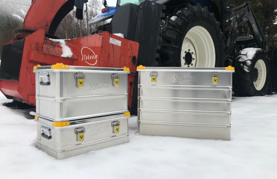 Aluminiumkisten von Viking im Schnee, neben einer Landmaschine aufgestellt